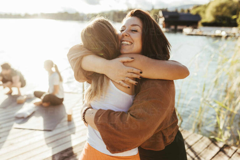 Umarmungen nach einer Yogastunde am See. Österreich, Kärnten, Pörtschach, Wörthersee